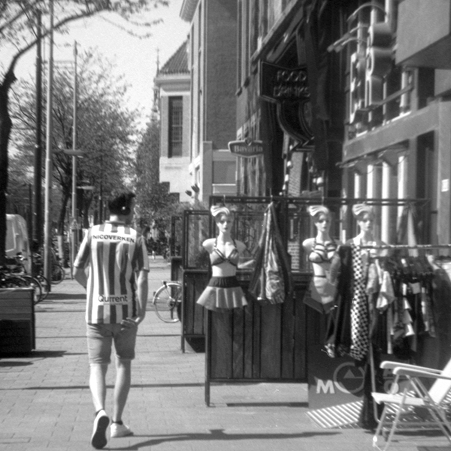 My beautiful stranger, black and white picture of man walking the street meeting mannequins
